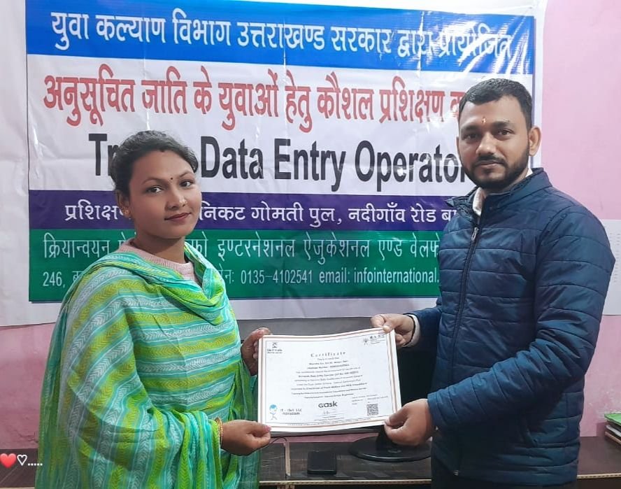 A trainee receiving her data entry operator certificate from a programme officer